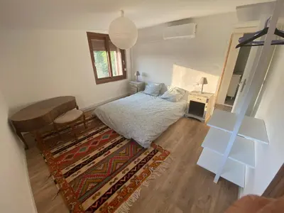 a bedroom with a bed and a table and a rug at Maison, Centre-ville, 6 lits, terrasse & parking in Apt
