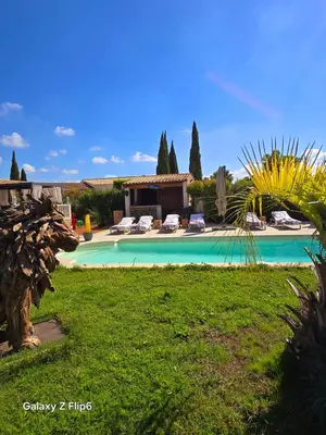 a swimming pool with chairs and a house in the background at L'endroit incontournable in Les Baïsses