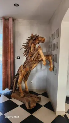 a wooden horse statue in a corner of a room at L'endroit incontournable in Les Baïsses