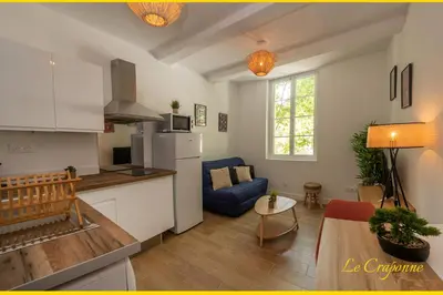 a kitchen and living room with a blue couch in a room at Le Craponne - Magnifique appartement cours principal plein centre avec parking in Salon-de-Provence