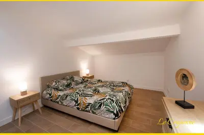 a bedroom with a bed and two night stands in it at Le Craponne - Magnifique appartement cours principal plein centre avec parking in Salon-de-Provence