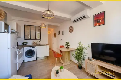 a kitchen and living room with a large tv and a table at Le Morgan - Magnifique appartement cours principal plein centre avec parking in Salon-de-Provence