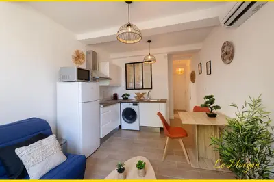 a living room with a blue couch and a kitchen at Le Morgan - Magnifique appartement cours principal plein centre avec parking in Salon-de-Provence
