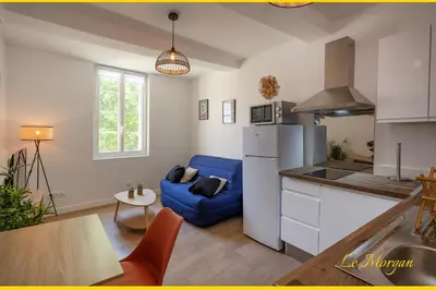 a kitchen and a living room with a blue couch at Le Morgan - Magnifique appartement cours principal plein centre avec parking in Salon-de-Provence