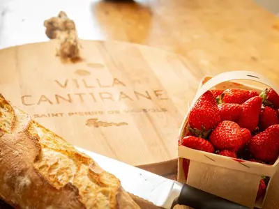 a basket of strawberries next to a piece of bread at Villa Cantirane in Saint-Pierre-de-Vassols