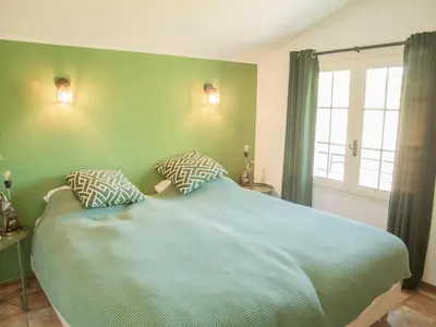 a bedroom with a large bed with two pillows at Villa Cantirane in Saint-Pierre-de-Vassols