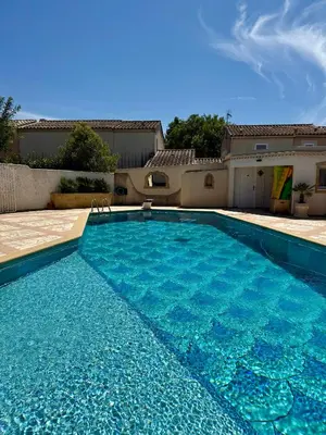 a large blue swimming pool in front of a house at Villa Victoire au coeur de la Provence in Venelles
