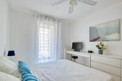 a white bedroom with a bed and a window at Le Fonction, meublé 4 étoiles, avec parking boxé in Aix-en-Provence