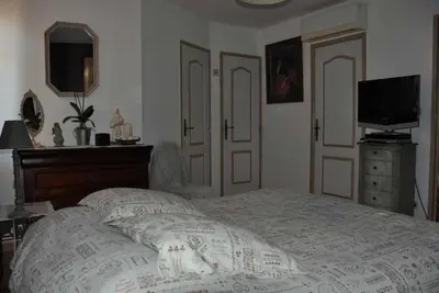 a bedroom with a bed with a television and a dresser at Chambres d'Hôtes dans villa avec piscine chez Raphaële in LʼIsle-sur-la-Sorgue