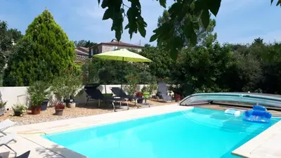 a blue swimming pool with an umbrella and chairs at Chambres d'Hôtes dans villa avec piscine chez Raphaële in LʼIsle-sur-la-Sorgue