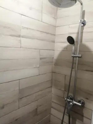 a shower in a bathroom with wooden tiles at Gite à la campagne à 15 kms d'Aix in Saint-Cannat
