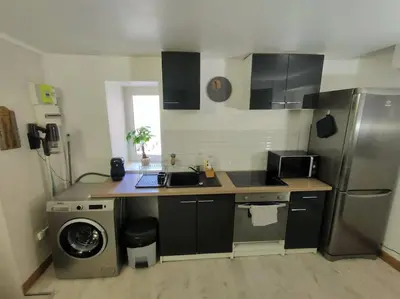 a kitchen with a sink and a washing machine at Maison de ville au coeur du centre historique, parking gratuit in Apt