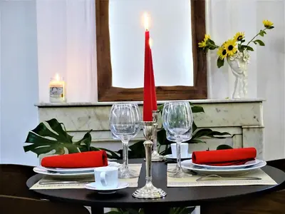 a table with a red candle and wine glasses at BLUE FOUNTAIN Luxueux Studio Aix Centre Historique -WIFI-SMART TV- in Aix-en-Provence
