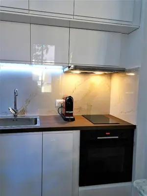 a kitchen with white cabinets and a counter with a sink at BLUE FOUNTAIN Luxueux Studio Aix Centre Historique -WIFI-SMART TV- in Aix-en-Provence