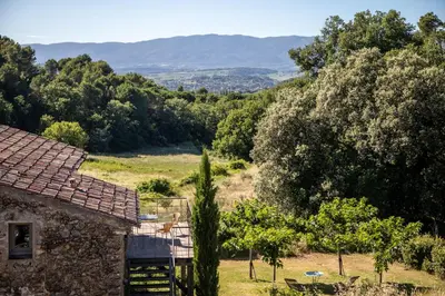 a house in a field with trees in the background at Domaine Les Perpetus in La Tour-dʼAigues