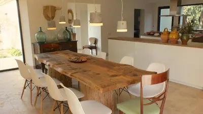a dining room with a wooden table and white chairs at Mas Notre Dame in Eygalières