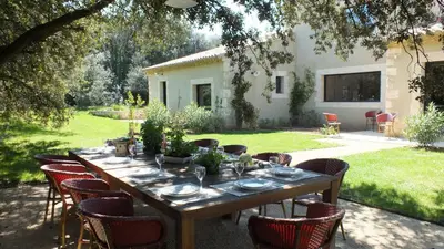 a wooden table and chairs in a yard at Mas Notre Dame in Eygalières