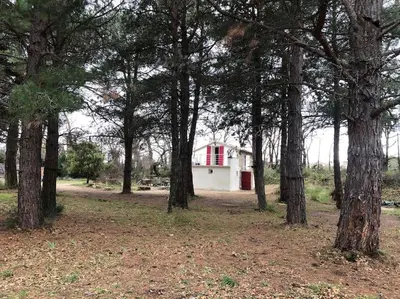a small house with a red door and a balcony at Le Cabanon de Vally in Caromb