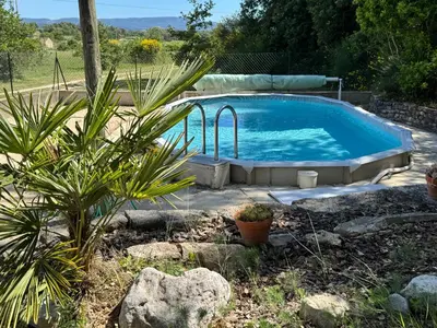 a large swimming pool in a yard with plants at Le Cabanon de Vally in Caromb