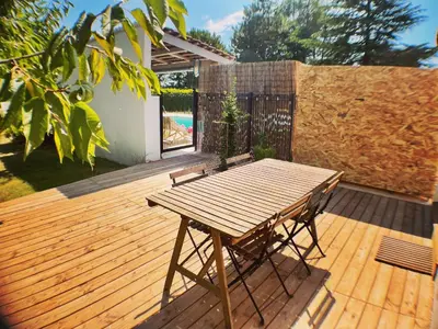 a wooden deck with a wooden table and a bench at Anse Coco Luberon - Au calme, gite en Provence avec piscine partagée et parking in Pertuis