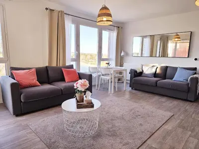 a living room with a couch and a table at Lakeside Provence - Appartement classé 4 étoiles, Vue sur le lac de Monteux, Parking sous-sol, double clim in Monteux