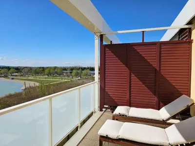 a balcony with chairs and a view of the water at Lakeside Provence - Appartement classé 4 étoiles, Vue sur le lac de Monteux, Parking sous-sol, double clim in Monteux