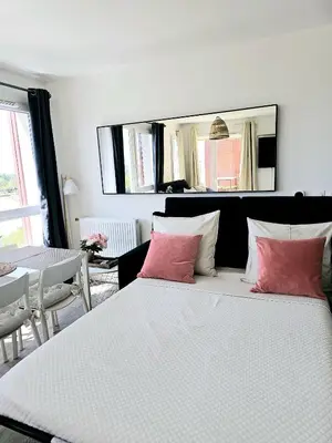 a bedroom with a large bed with two pink pillows at Lakeside Provence - Appartement classé 4 étoiles, Vue sur le lac de Monteux, Parking sous-sol, double clim in Monteux