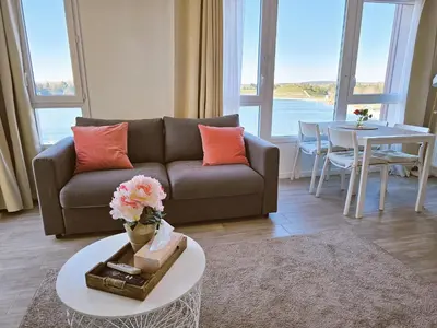 a living room with a couch and a table at Lakeside Provence - Appartement classé 4 étoiles, Vue sur le lac de Monteux, Parking sous-sol, double clim in Monteux