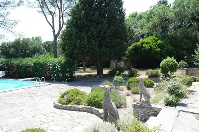 two statues of cats in a garden next to a pool at very pleasant provençal mas, typical to the region, with heated pool in saint remy de provence - 9 people in Saint-Rémy-de-Provence