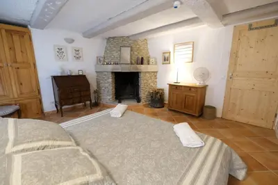 a living room with a bed and a fireplace at very pleasant provençal mas, typical to the region, with heated pool in saint remy de provence - 9 people in Saint-Rémy-de-Provence