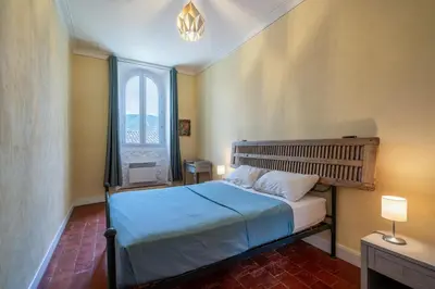 a bedroom with a bed with a large window at Domaine Mas Côté Cour in Maubec