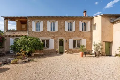 a large house with a courtyard in front of it at Domaine Mas Côté Cour in Maubec