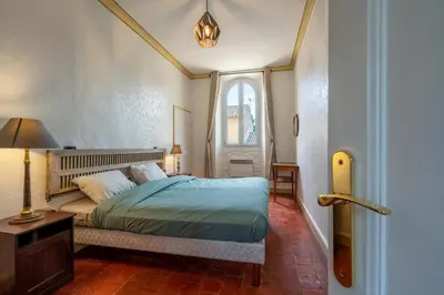 a bedroom with a bed and a window at Domaine Mas Côté Cour in Maubec