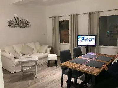 a room with a table and chairs and a painting on the wall at COSY PLACE Aix-en-Provence, centre historique, WIFI Fibre Optique gratuit in Aix-en-Provence