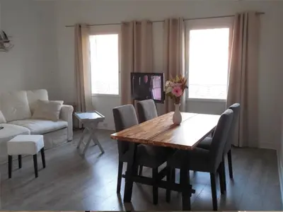 a living room with a couch and a table with chairs at COSY PLACE Aix-en-Provence, centre historique, WIFI Fibre Optique gratuit in Aix-en-Provence