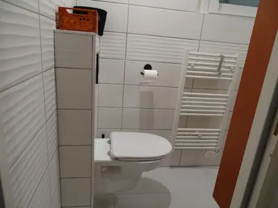 a bathroom with a toilet with a toilet paper dispenser at Chambre indépendante in Apt