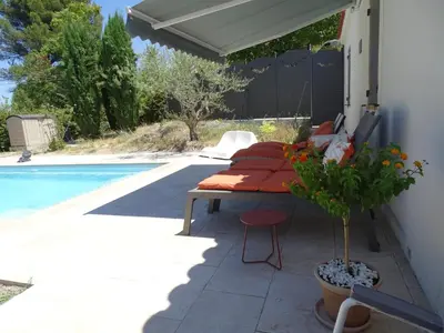 a patio with a table and chairs next to a pool at Chambre indépendante in Apt
