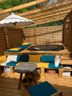 a patio with a hot tub and a table and chairs at Maisonnette atypique cadarache-iter in Saint-Paul-lez-Durance
