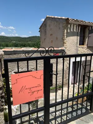 a sign on a black fence with a building at Maisonnette atypique cadarache-iter in Saint-Paul-lez-Durance