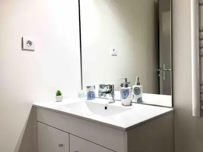 a bathroom with a white sink and a mirror at Ma place au sud Aix Parking in Aix-en-Provence