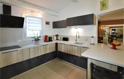 a kitchen with wooden cabinets and a sink at Stunning Home In Châteaurenard in Châteaurenard