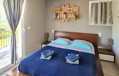 a bed with blue sheets and blue pillows on it at Gorgeous Home In Puget in Puget