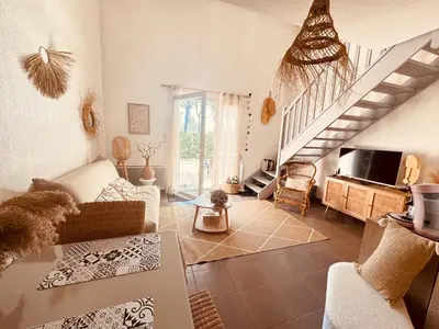 a living room with a couch and a staircase at Maison de vacances au calme 4 personnes residence avec piscine in Aubignan