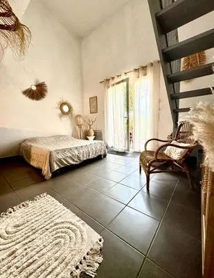 a bedroom with a bed and a staircase and a chair at Maison de vacances au calme 4 personnes residence avec piscine in Aubignan