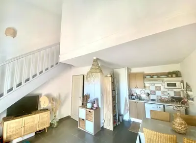 a living room with a staircase and a kitchen at Maison de vacances au calme 4 personnes residence avec piscine in Aubignan