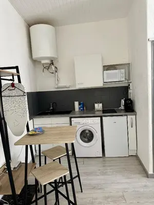 a kitchen with a table and a washing machine at Studio3 proche Quai Rouget in LʼIsle-sur-la-Sorgue