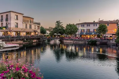 a river in a town with buildings and a bridge at Studio3 proche Quai Rouget in LʼIsle-sur-la-Sorgue