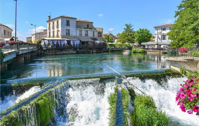 a river with a waterfall in a city at Awesome Apartment In Rustrel in Rustrel