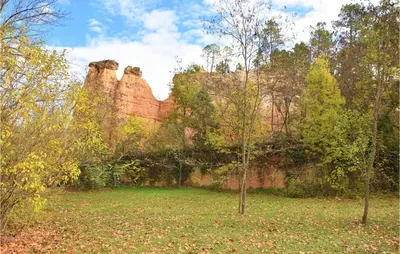 a rock wall with two trees in a field at Awesome Apartment In Rustrel in Rustrel