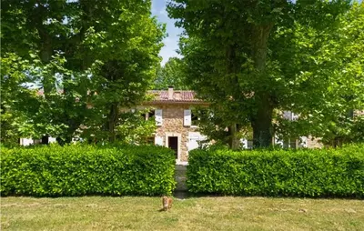 a stone house with trees and bushes in front of it at Awesome Apartment In Rustrel in Rustrel
